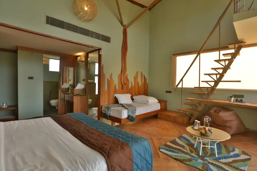 Loft suite with double-height forest windows at a luxury stay