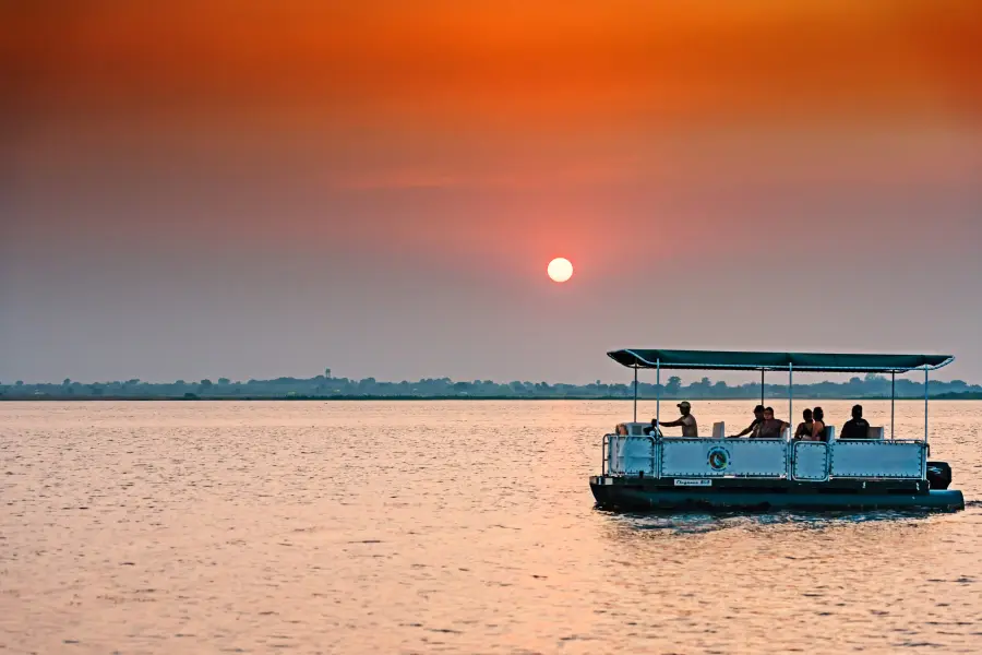 Boat safari on the backwaters silhouetted against the sunset
