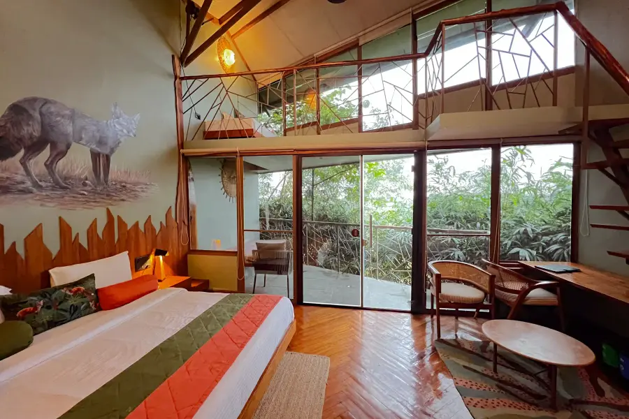 Loft suite with double-height forest windows at a luxury stay