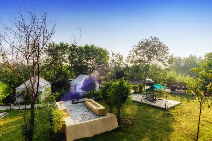 Safari tents and bicycle stand in the garden at a luxury stay