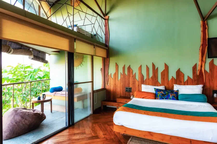 King bed and hand-carved timber headboard in a room at a luxury stay