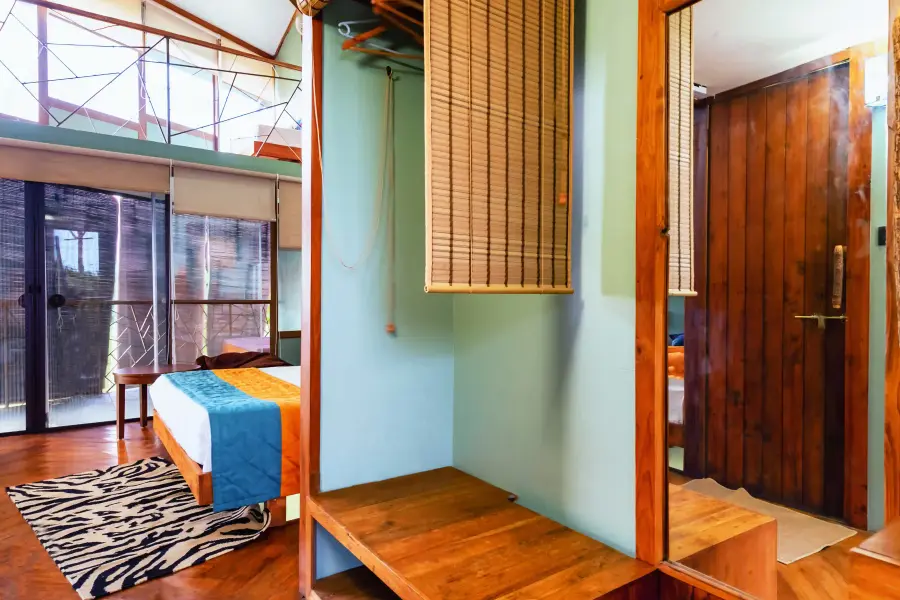 Loft suite with double-height forest windows at a luxury stay