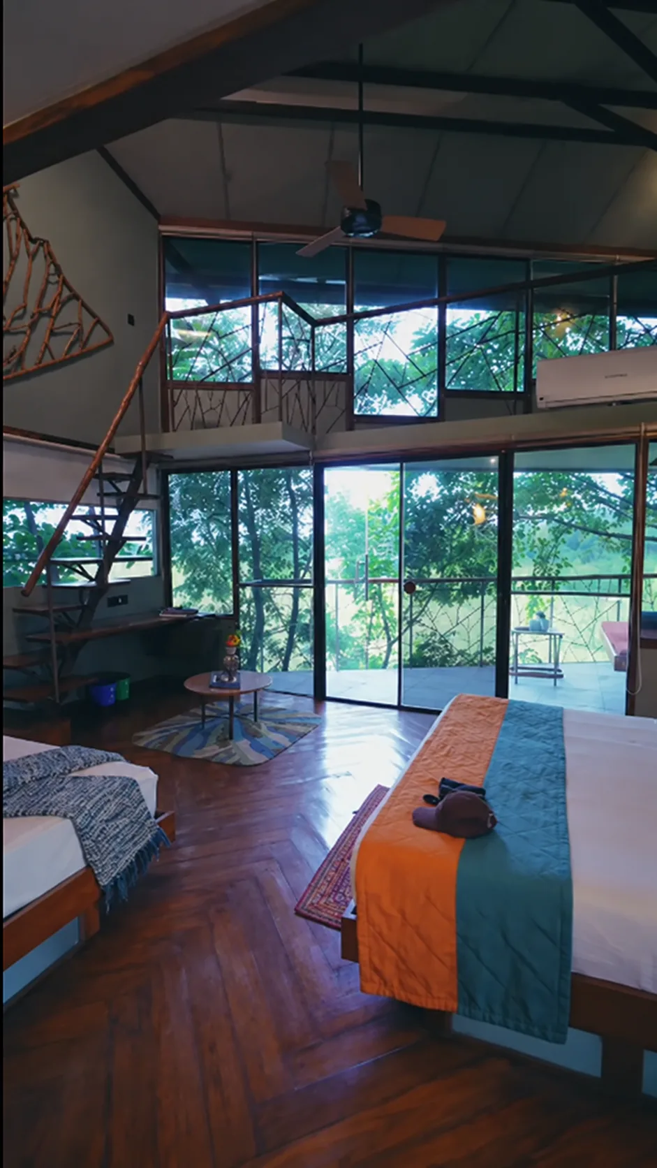 Duplex forest-facing room with twin beds, a loft and floor-to-ceiling windows opening onto the trees