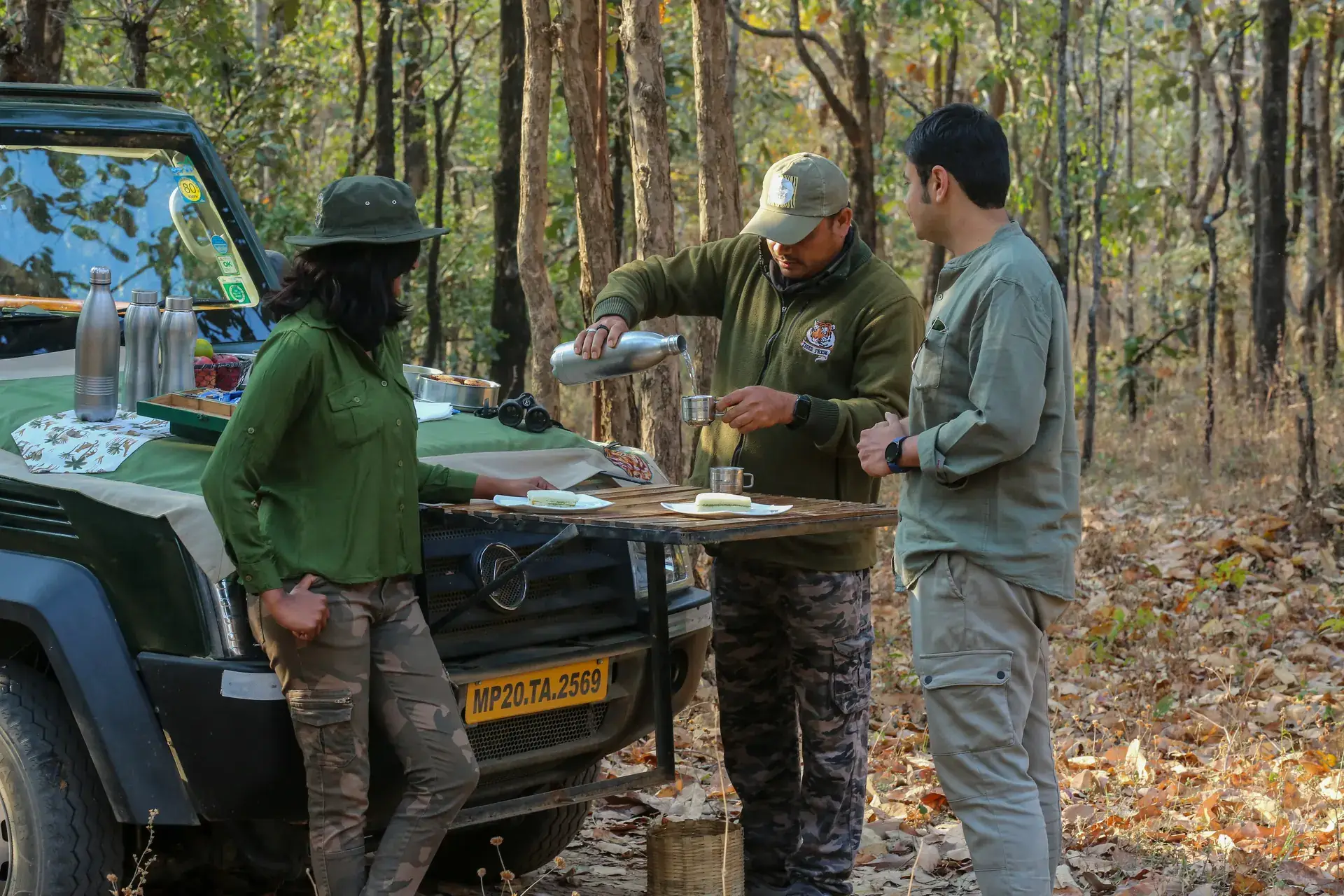 Safari guests with a naturalist beside a Gypsy in the Pench forest