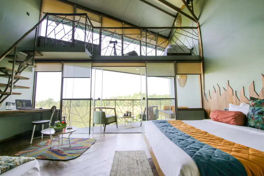 Split-level loft suite with a lounge and forest outlook at a luxury stay