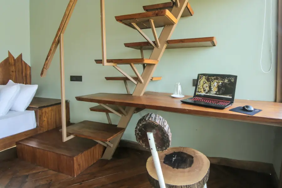 Timber writing desk beside the loft stair in a suite at a luxury stay
