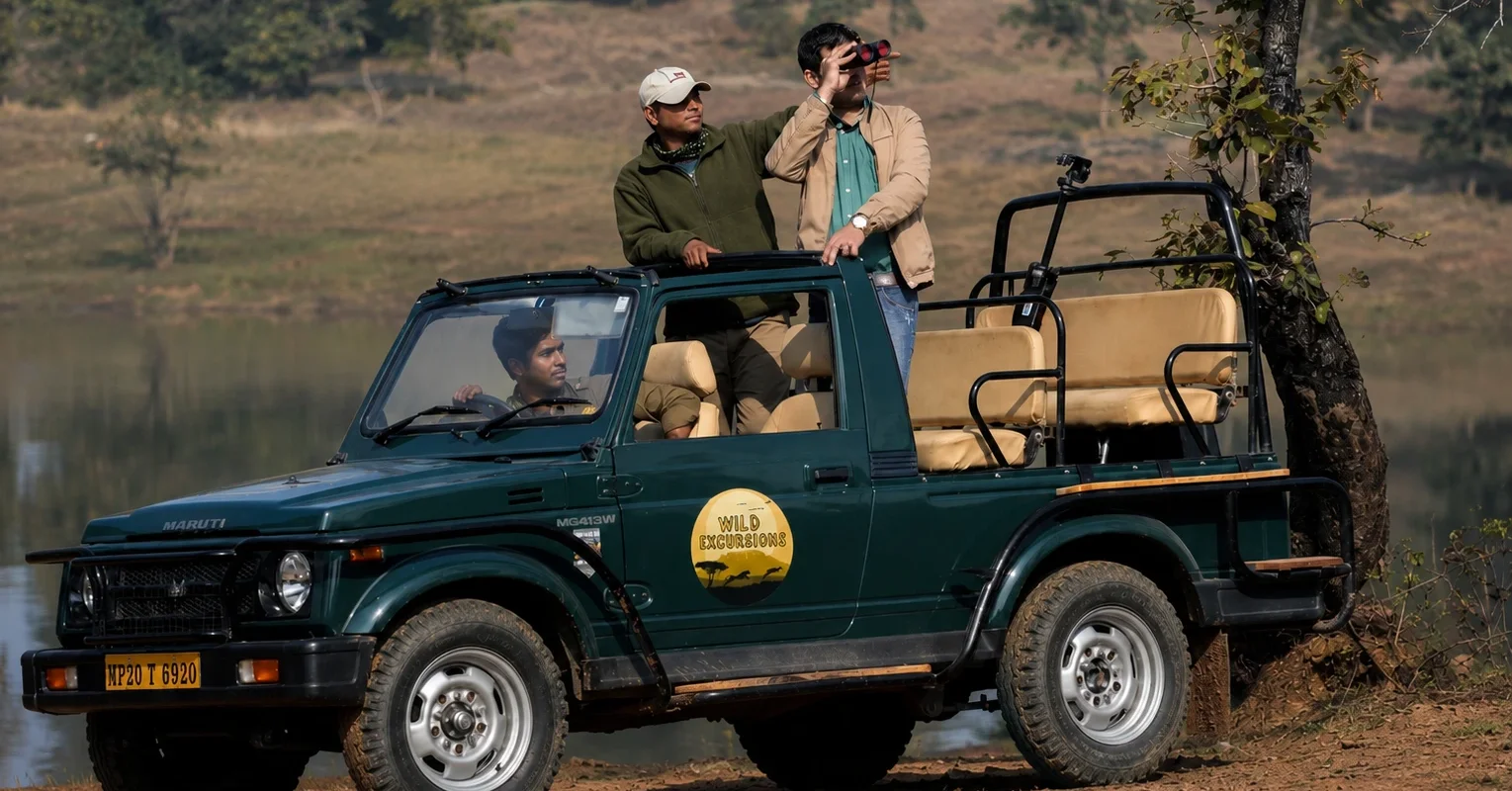 A Wild Excursions naturalist and driver on a safari jeep with a guest, at a Central India tiger reserve